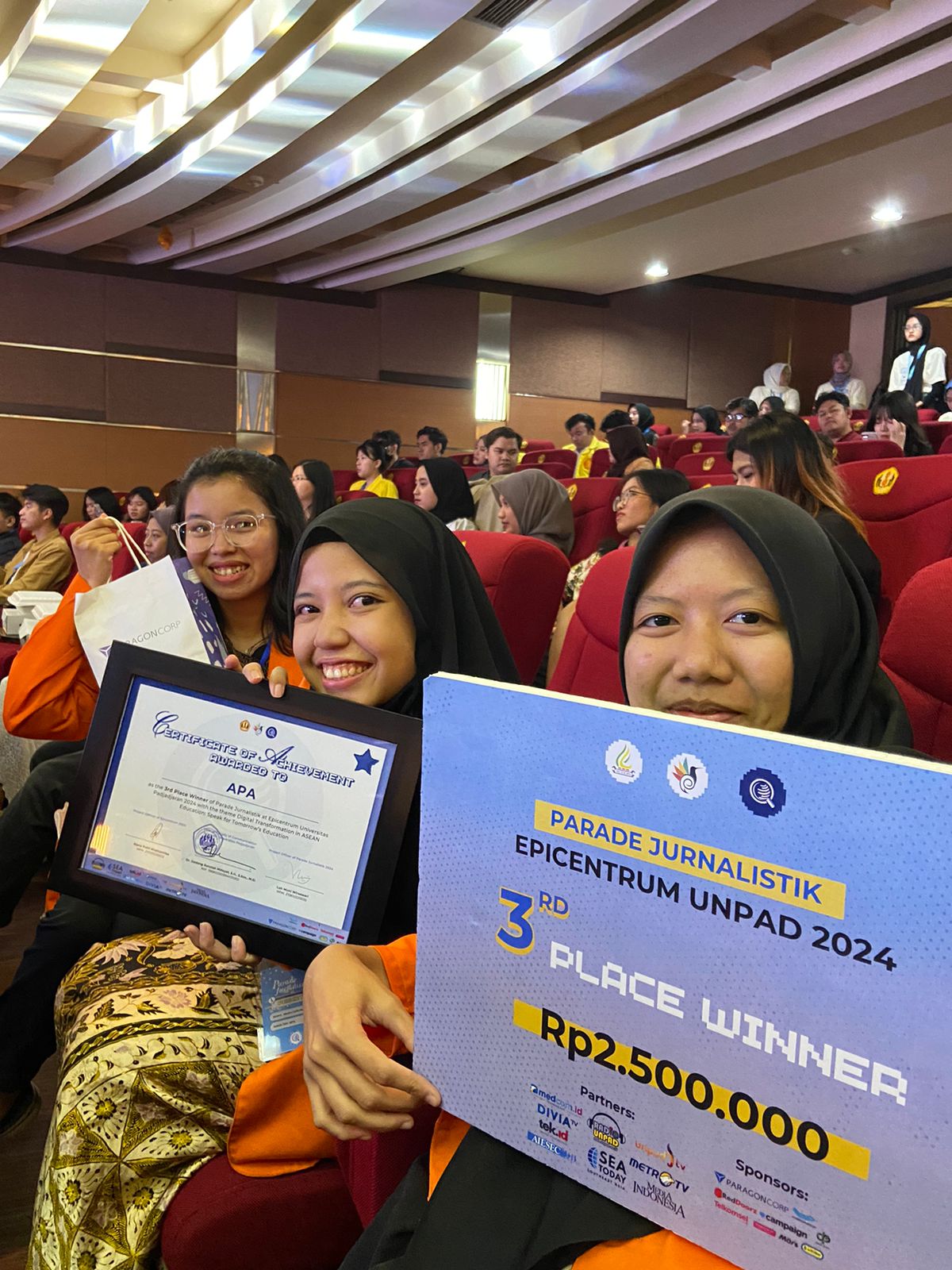 Tim APA yang beranggotakan Almira Carin Rezdianti, Putri Asma Nur Afifah, dan Ariadne Khatarina Moniaga berhasil meraih juara ketiga pada ajang Parade Jurnalistik Epicentrum 2024 pada Rabu, 22 Mei 2024 malam. Penghargaan tersebut diterima secara langsung oleh tim APA pada acara Malam Penganugerahan yang digelar di Auditorium Pascasarjana Fikom Universitas Padjadjaran. Dok. Rachma Tri Widuri.